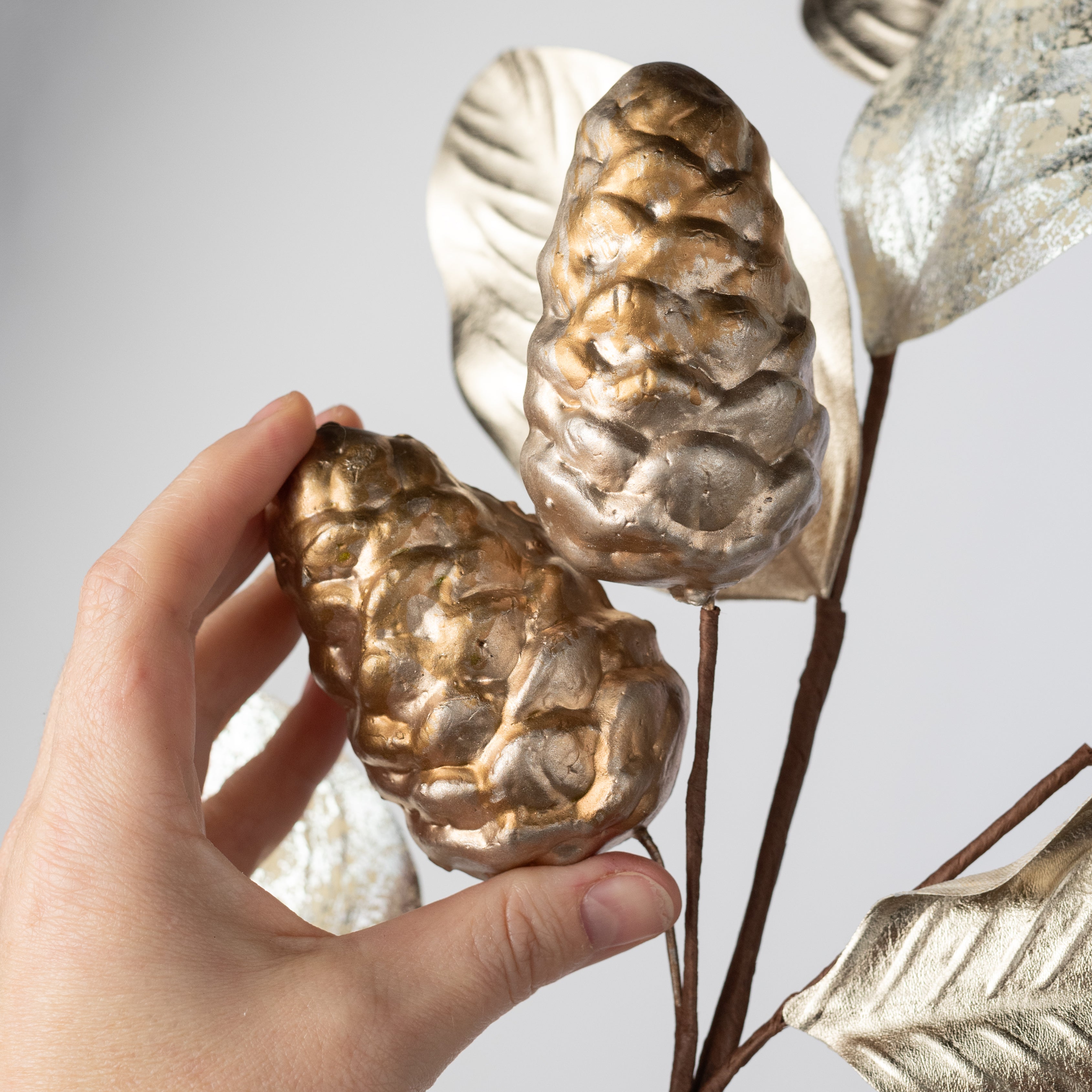 29" Metallic Magnolia Leaves & Pinecones Spray: Champagne