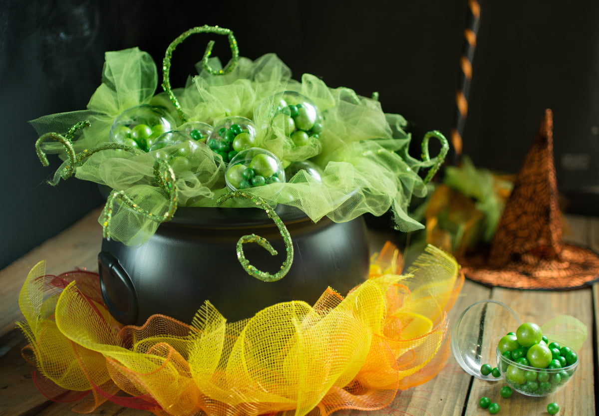 Cauldron with green tulle and a yellow-orange mesh flame-shaped base