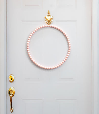 17.75" Wood Bead Wreath: Quartz Blush Pink Lifestyle Photo